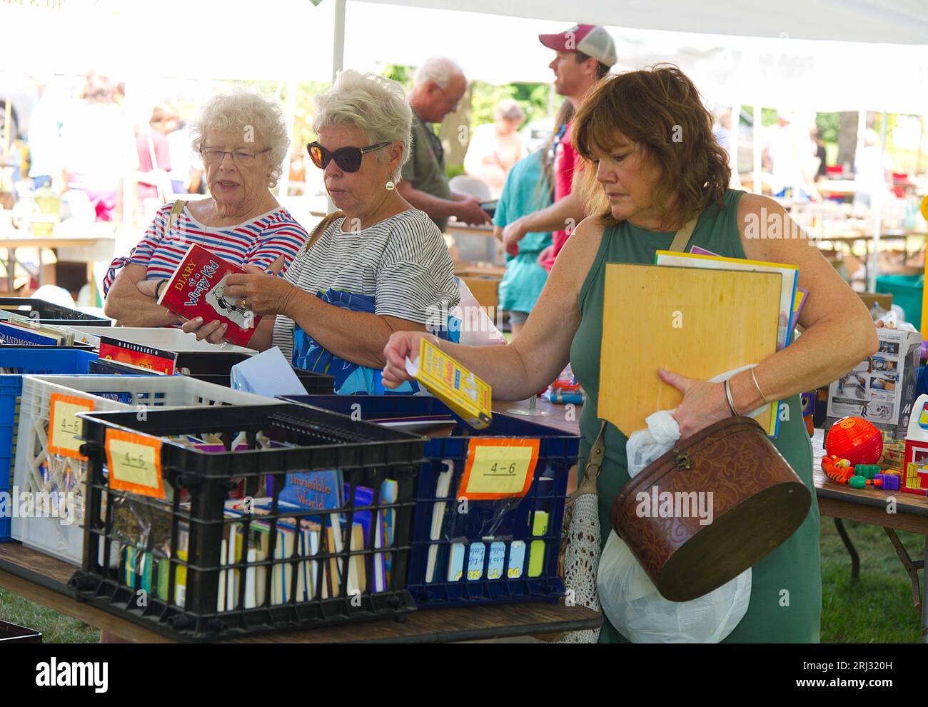 women examining books at an annual church fair and flea market dennis massachusetts on cape cod usa 2rj320h